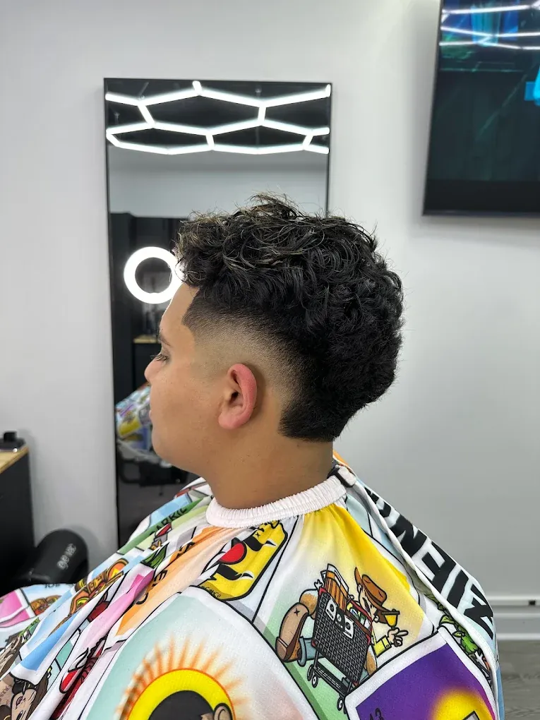Curly top with a low taper fade finished at Blends Barbershop in Denham Springs